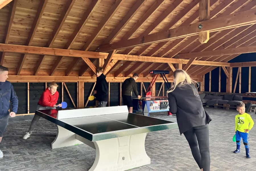 Coogherveld Camping faciliteiten Mensen spelen rond de ping pong tafel